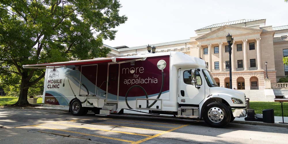 The ARH Mobile Clinic parked in front of a large government building